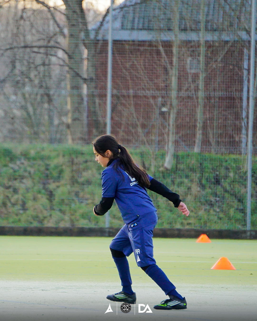 B&W close up of football boots on artificial pitch